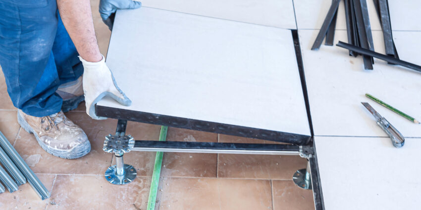 Access Floor Replacement in Data Center. Technician places Access floor tile in grid.